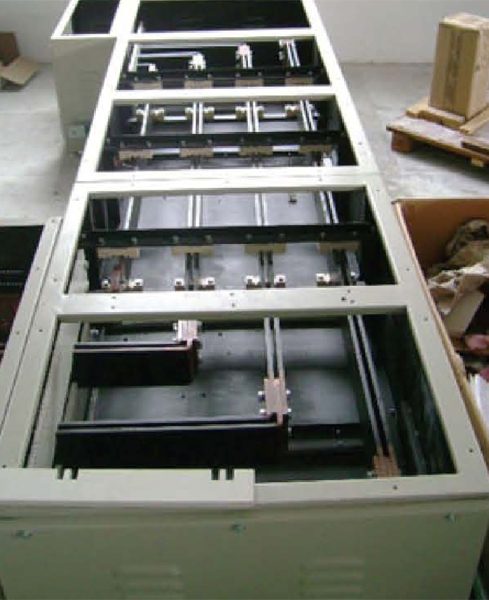Open medium-voltage panel showing copper busbars, insulators and current transformers